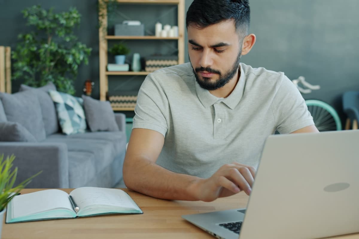 Geschäftsreisender arbeitet am Schreibtisch im möblierten Apartment